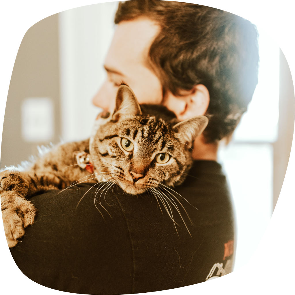 Homme portant un chat dans les bras.