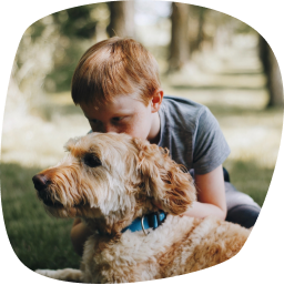 Petit garçon embrassant la tête d’un chien.